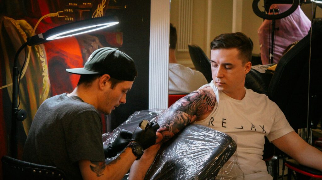 Tattoo artist working on an arm sleeve. 