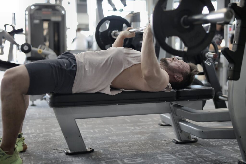 A man doing bench press at the gym.